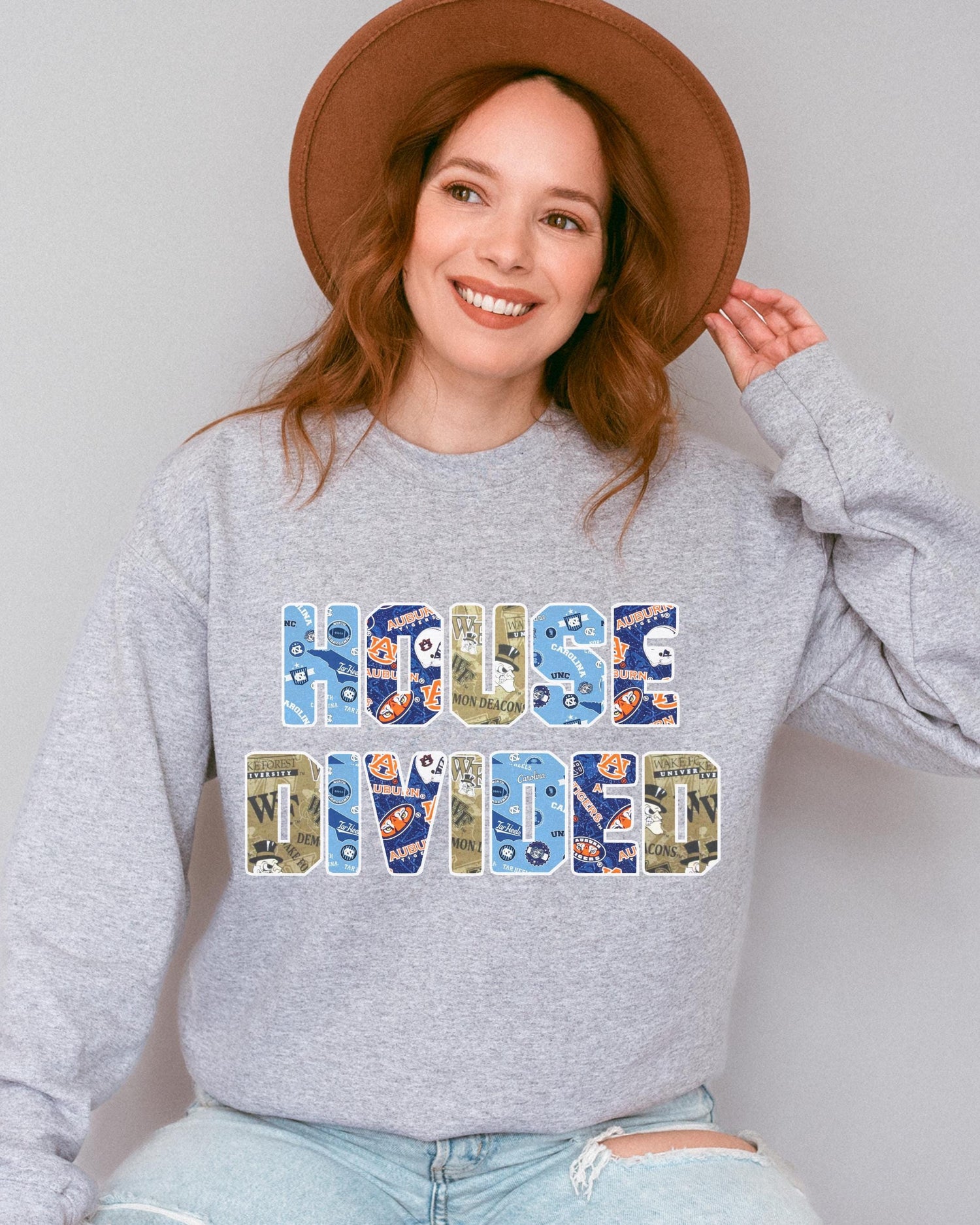 a woman wearing a house divided sweatshirt and a hat